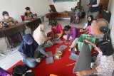 Relawan menyelesaikan pembuatan masker di Kelurahan Dermo, Kota Kediri, Jawa Timur, Jumat (3/4/2020). Masker yang diproduksi dari hasil donasi sejumlah pihak tersebut akan didistribusikan secara gratis kepada masyarakat guna mencegah penyebaran COVID-19. Antara Jatim/Prasetia Fauzani/zk.