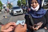 Petugas memeriksa Kartu Tanda Penduduk (KTP) pengendara saat dilakukan seleksi pengendara masuk wilayah di Jalan Urip Sumoharjo Kota Madiun, Jawa Timur, Kamis (2/4/2020). Seleksi pengendara masuk wilayah Kota Madiun dengan menolak pengendara yang bukan warga kota Madiun memasuki wilayah tersebut dimaksudkan untuk mengurangi pergerakan masyarakat dari luar daerah di wilayah tersebut untuk pencegahan penyebaran COVID-19 atau virus corona. Antara Jatim/Siswowidodo/zk.