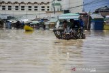 Warga menggunakan delman untuk melintasi banjir di Jalan Raya Dayeuhkolot, Kabupaten Bandung, Jawa Barat, Minggu (5/4/2020). Sedikitnya 104 ribu warga dari 13 kecamatan di kawasan Bandung Selatan terdampak banjir akibat luapan Sungai Citarum dan intensitas curah hujan yang tinggi. ANTARA JABAR/Novrian Arbi/agr