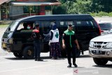 Petugas memeriksa suhu tubuh dan identitas warga yang memasuki wilayah kabupaten Aceh Jaya di jalan perbatasan antara Kabupaten Aceh Besar  dengan Aceh Jaya, Lamno, Aceh, Minggu (5/4/2020). Pemerintah Kabupaten Aceh Jaya memperketat jalur masuk terhadap warga luar terutama dari daerah zona merah dengan melakukan pemeriksaan dan pendataan kependudukan sebagai upaya mengantisipasi penyebaran virus Corona (COVID-19). Antara Aceh / Irwansyah Putra.