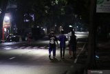 Warga berjalan kaki di Jalan Pahlawan Kusuma Bangsa, Kota Kediri, Jawa Timur, Minggu (5/4/2020) malam. Pusat kuliner kaki lima di daerah itu tutup seiring pemberlakuan 'physical distancing' atau jaga jarak secara fisik sebagai upaya mencegah penyebaran COVID-19. Antara Jatim/Prasetia Fauzani/zk