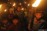 Anak-anak membaca sholawat sambil membawa obor berkeliling kampung di Kelurahan Gladak Anyar, Pamekasan, Jawa Timur, Senin (6/4/2020). Pembacaan sholawat tersebut sebagai permohonan agar bangsa Indobesia segera terbebas dari musibah wabah COVID-19. Antara Jatim/Saiful Bahri/zk