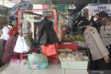 Polisi memantau harga sembako di Pasar Nambangan Surabaya, Jawa Timur, Selasa (7/4/2020). Operasi pasar yang dilakukan pihak kepolisian setempat itu untuk memantau harga sekaligus ketersediaan sembilan bahan pokok (sembako) yang dijual di pasaran. Antara Jatim/Didik/Zk