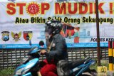 Warga melintas di depan spanduk bertuliskan 'stop mudik' di Kota Kediri, Jawa Timur, Rabu (8/4/2020). Polresta Kediri menghimbau masyarakat untuk tidak mudik guna menghindari penyebaran COVID-19. Antara Jatim/Prasetia Fauzani/zk.