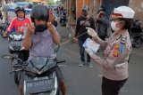 Polisi membagikan masker kepada pengendara sepeda motor dalam giat operasi keselamatan agung 2020 di Denpasar, Bali, Rabu (8/4/2020). Kegiatan yang digelar Polresta Denpasar tersebut untuk memberikan pemahaman pentingnya mengikuti imbauan pemerintah dalam upaya mencegah penyebaran COVID-19 atau Virus Corona. ANTARA FOTO/Nyoman Hendra Wibowo/nym