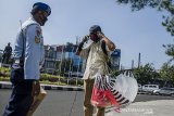 Prajuit TNI AU membagikan masker kepada pedagang di depan Lanud Husein Sastranegara, Bandung, Jawa Barat, Kamis (9/4/2020). Ratusan masker dibagikan oleh TNI AU Lanud Husein Sastranegara kepada warga dan pengendara untuk digunakan saat beraktivitas di luar rumah sebagai antisipasi penyebaran pandemi COVID-19. ANTARA JABAR/Novrian Arbi/agr