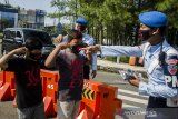 Prajuit TNI AU membagikan masker kepada anak anak di depan Lanud Husein Sastranegara, Bandung, Jawa Barat, Kamis (9/4/2020). Ratusan masker dibagikan oleh TNI AU Lanud Husein Sastranegara kepada warga dan pengendara untuk digunakan saat beraktivitas di luar rumah sebagai antisipasi penyebaran pandemi COVID-19. ANTARA JABAR/Novrian Arbi/agr