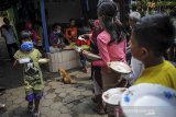 Warga antre untuk mendapatkan makan siang gratis di Lio Genteng, Astana Anyar, Bandung, Jawa Barat, Jumat (10/4/2020). Pembagian makan gratis hasil swadaya masyarakat itu ditujukan sebagai bentuk kepedulian terhadap warga terdampak COVID-19 yang kehilangan mata pencahariannya di wilayah tersebut. ANTARA JABAR/Raisan Al Farisi/agr