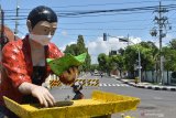 Patung penjual nasi pecel mengenakan masker di Kota Madiun, Jawa Timur, Jumat (10/4/2020). Pemkot Madiun akan memasang masker pada semua patung yang ada di wilayah itu sebagai salah satu bentuk kampanye penggunaan masker bagi masyarakat guna mencegah penularan COVID-19. Antara Jatim/Siswowidodo/zk