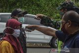 Petugas Gugus Tugas COVID-19 memeriksa suhu badan pemudik kendaraan di Perbatasan Tasikmalaya-Ciamis, Jembatan Cirahong, Kabupaten Ciamis, Jawa Barat, Jumat (10/4/2020). Pemkab Ciamis memberlakukan karantina lokal terbatas dengan mendirikan  sembilan Posko percepatan penanganan COVID-19 di wilayah perbatasan. ANTARA JABAR/Adeng Bustomi/agr