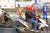Petugas kepolisian dari polres Pasuruan Kota berpakaian superhero menyemprotkan cairan disinfektan di jalan Panglima Sudirman kawasan Kebonagung, Pasuruan , Jawa Timur, Kamis (9/4/2020). Penyemprotan cairan disinfektan tersebut bertujuan untuk mengantisipasi penyebaran Virus Corona (COVID-19). Antara Jatim/Umarul Faruq/zk