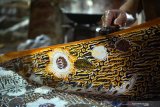 Perajin menyelesaikan polesan terakhir produk batik tulis di UMKM Batik Gajah Mada di Mojosari, Tulungagung, Jawa Timur, Kamis (9/4/2020). Pandemi wabah COVID-19 yang terjadi di sebagian besar wilayah di Indonesia beberapa pekan terakhir telah menyebabkan mayoritas UMKM batik di daerah itu terpaksa menghentikan produksi akibat minimnya permintaan pelanggan, terutama dari sektor korporat/bisnis yang biasanya memiliki pesanan dengan omzet besar. Antara Jatim/Destyan Sujarwoko/zk