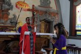 Umat Katolik melakukan kebaktian pada Misa Jumat Agung di Gereja Katolik Roh Kudus Paroki Babakan, Badung, Bali, Jumat (10/4/2020). Misa Jumat Agung di Gereja tersebut hanya terbatas untuk beberapa umat yang hadir, sementara umat lainnya sebagian besar mengikutinya melalui media daring di rumah masing-masing sebagai upaya pencegahan penyebaran COVID-19. ANTARA FOTO/Nyoman Hendra Wibowo/nym