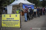 Petugas memeriksa suhu tubuh pemudik yang akan menuju Sumedang di perbatasan Kabupaten Bandung dengan Kabupaten Sumedang di Jatinangor, Kabupaten Sumedang, Jawa Barat, Sabtu (11/4/2020). Pemerintah Kabupaten Sumedang memberlakukan karantina wilayah parsial (KWP) dengan mendirikan posko tim gugus tugas COVID-19 di sejumlah titik perbatasan untuk mencegah penyebaran virus Corona oleh para carrier yang dibawa pemudik. ANTARA JABAR/Raisan Al Farisi/agr