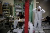 Pekerja mencoba alat pelindung diri (APD) yang telah selesai diproduksi di Antapani, Bandung, Jawa Barat, Minggu (12/4/2020). Beberapa pelaku usaha konveksi di Kota Bandung beralih produksi dari kaos distro menjadi APD akibat minimnya permintaan kaos distro dampak dari mewabahnya COVID-19 di Indonesia. ANTARA JABAR/Raisan Al Farisi/agr
