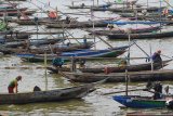 Nelayan di Kampung Bulak Cumpat beraktivitas di atas perahu yang ditambatkan di Pantai Kenjeran, Surabaya, Jawa Timur, Minggu (12/4/2020). Para nelayan di daerah tersebut mengaku pendapatan mereka turun drastis akibat sulitnya menjual hasil tangkapan ikan dan sepinya kunjungan wisatawan untuk menyewa jasa perahu wisata akibat COVID-19. Antara Jatim/Moch Asim/zk.