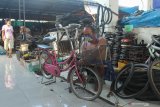 Pedagang memperbaiki sepeda angin untuk dijual di pasar barang bekas Gembong Asih, Surabaya, Jawa Timur, Minggu (12/4/2020). Para pedagang di pasar itu mengaku pengunjung pasar menurun drastis yang berdampak pada pendapatannya akibat COVID-19. Antara Jatim/Didik/Zk
