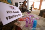 Pengurus Persatuan Wartawan Indonesia Provinsi Kalimantan Selatan menyiapkan hand sanitizer dan masker untuk jurnalis di Gedung PWI Kalsel di Banjarmasin, Kalimantan Selatan, Senin (13/4/2020). PWI Kalimantan Selatan membagikan hand sanitizer, masker dan sembako kepada wartawan media cetak, elektronik dan online untuk mencegah penyeberan virus COVID-19 terutama di kalangan wartawan yang menjadi garda terdepan dalam memberikan informasi terkait wabah COVID-19 di Kalimantan Selatan. Foto Antaranews Kalsel/Bayu Pratama S.