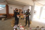 Ketua Persatuan Wartawan Indonesia (PWI) Provinsi Kalimantan Selatan Zainal Helmie (kiri) menyerahkan paket sembako kepada jurnalis di Gedung PWI Kalsel di Banjarmasin, Kalimantan Selatan, Senin (13/4/2020). PWI Kalimantan Selatan membagikan hand sanitizer, masker dan sembako kepada wartawan media cetak, elektronik dan online untuk mencegah penyeberan virus COVID-19 terutama di kalangan wartawan yang menjadi garda terdepan dalam memberikan informasi terkait wabah COVID-19 di Kalimantan Selatan. Foto Antaranews Kalsel/Bayu Pratama S.