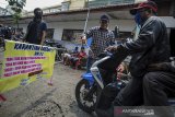 Warga menyemprotkan cairan disinfektan kepada pendatang di wilayah karantina mandiri di Kebonwaru, Bandung, Jawa Barat, Senin (13/4/2020). Karantina wilayah mandiri tersebut dilakukan di beberapa wilayah di Kota Bandung guna memutus penyebaran COVID-19. ANTARA JABAR/Raisan Al Farisi/agr