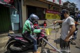 Warga menyemprotkan cairan disinfektan kepada pendatang di wilayah karantina mandiri di Kebonwaru, Bandung, Jawa Barat, Senin (13/4/2020). Karantina wilayah mandiri tersebut dilakukan di beberapa wilayah di Kota Bandung guna memutus penyebaran COVID-19. ANTARA JABAR/Raisan Al Farisi/agr