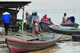 Warga berjalan turun daru perahu penyeberangan di tepi Sungai Batanghari, Mudung Laut, Pelayangan, Jambi, Jumat (10/4/2020). Pemerintah mengimbau seluruh warga untuk mengenakan masker saat beraktivitas di luar rumah guna mencegah penyebaran COVID-19. ANTARA FOTO/Wahdi Septiawan/wsj.