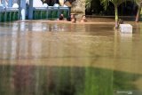 Sejumlah anak melewati banjir yang merendam kawasan Kraton, Pasuruan, Jawa Timur, Selasa (14/4/2020). Banjir sedalam satu meter yang hampir melumpuhkan Jalur Pantura tersebut terjadi akibat meluapnya Sungai Welang setelah diguyur hujan sejak Senin (13/4) malam. Antara Jatim/Umarul Faruq/zk