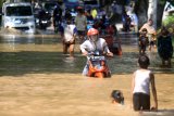 Kendaraan bermotor menerobos banjir yang menggenangi kawasan Jalan Raya Pantura Kraton, Pasuruan, Jawa Timur, Selasa (14/4/2020). Banjir sedalam satu meter yang hampir melumpuhkan Jalur Pantura tersebut terjadi akibat meluapnya Sungai Welang setelah diguyur hujan sejak Senin (13/4) malam. Antara Jatim/Umarul Faruq/zk
