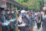 Warga memdapatkan makanan gratis di halaman Masjid Jami, Banjarmasin, Kalimantan Selatan, Selasa (14/4/2020). Polda Kalimantan Selatan bersama TNI dan Pemerintah Provinsi Kalsel membagikan makanan gratis dan masker sebagai bentuk kepedulian terhadap warga terdampak COVID-19 di Kota Banjarmasin. Foto Antaranews Kalsel/Bayu Pratama S.