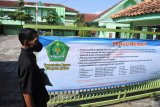 Petugas keamanan berada dipagar Kantor Kementerian Agama (Kemenag) Kabupaten Jember, Jawa Timur, Selasa (14/4/2020). Kantor Kemenag dan Kantor Urusan Agama (KUA) di Jember ditutup terkait penetapan pasien positif COVID-19 di Jember dan diketahui pasien tersebut pernah mengikuti pelatihan haji di Asrama Haji Sukolilo Surabaya pada 9-18 Maret 2020. Antara Jatim/Seno/zk