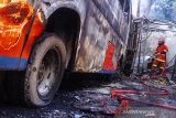 Petugas pemadam kebakaran melakukan pendinginan usai memadamkam api  pada bus karyawan PO Warga Baru yang terbakar di Jalan Raya Cidomba, Telukjambe Timur, Karawang, Jawa Barat, Selasa (14/4/2020). Kecelakaan bus yang membawa karyawan tersebut terbakar setelah menabrak enam kios ANTARA JABAR/M Ibnu Chazar/agr