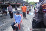 Warga antre untuk mendapatkan makanan gratis di halaman Masjid Jami, Banjarmasin, Kalimantan Selatan, Selasa (14/4/2020). Polda Kalimantan Selatan bersama TNI dan Pemerintah Provinsi Kalsel membagikan makanan gratis dan masker sebagai bentuk kepedulian terhadap warga terdampak COVID-19 di Kota Banjarmasin. Foto Antaranews Kalsel/Bayu Pratama S.