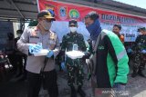 Kapolda Kalsel Irjen Pol Yazid Fanani (kiri) didampingi Danrem 101/Antasari Kolonel Inf M Syech Ismed (tengah) memberikan makanan gratis kepada warga di halaman Masjid Jami, Banjarmasin, Kalimantan Selatan, Selasa (14/4/2020). Polda Kalimantan Selatan bersama TNI dan Pemerintah Provinsi Kalsel membagikan makanan gratis sebagai bentuk kepedulian terhadap warga terdampak COVID-19 di Kota Banjarmasin. Foto Antaranews Kalsel/Bayu Pratama S.