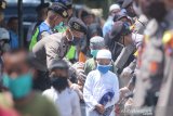 Warga antre untuk mendapatkan makanan gratis di halaman Masjid Jami, Banjarmasin, Kalimantan Selatan, Selasa (14/4/2020). Polda Kalimantan Selatan bersama TNI dan Pemerintah Provinsi Kalsel membagikan makanan gratis dan masker sebagai bentuk kepedulian terhadap warga terdampak COVID-19 di Kota Banjarmasin. Foto Antaranews Kalsel/Bayu Pratama S.