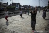 Warga berjemur sekaligus berolahraga di samping rel kereta api di Andir, Bandung, Jawa Barat, Rabu (15/4/2020). Saat pandemi COVID-19 yang tengah mewabah di Indonesia, warga yang tinggal di bantaran rel kereta api tersebut memanfaatkan lengangnya perjalan kereta api untuk berjemur dan berolahraga agar menjaga imunitas tubuh. ANTARA JABAR/Raisan Al Farisi/agr