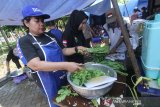 Petugas Taruna Siaga Bencana (Tagana) memasak makanan di dapur umum di kawasan Taman Kamboja, Banjarmasin, Kalimantan Selatan, Rabu (15/4/2020). Dapur umum yang digelar oleh petugas gabungan terdiri dari Tagana, Pemerintah Kota Banjarmasin, TNI dan Polri tersebut untuk membantu menyediakan makanan guna meringankan beban masyarakat berpenghasilan harian akibat terdampak pandemi COVID-19. Foto Antaranews Kalsel/Bayu Pratama S.