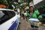 Petugas Bea Cukai membagikan paket sembako kepada pengemudi ojek daring di Banjarmasin, Kalimantan Selatan, Kamis (16/4/2020). Sebanyak 786 paket sembako di bagikan komunitas Maritim yang terdiri dari Kantor Wilayah Bea Cukai Kalimantan Bagian Selatan dan KPPBC TMP B Banjarmasin, Kantor Kesyahbandaran dan Otoritas Pelabuhan Banjarmasin dan PT Pelabuhan Indonesia III (persero) cabang Banjarmasin kepada masyarakat untuk membantu meringankan beban ekonomi warga yang terdampak virus COVID-19. Foto Antaranews Kalsel/Bayu Pratama S.