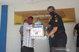 Kepala Kantor Pelayanan dan Pengawasan Bea Cukai tipe madya Pabean B Banjarmasin Kurnia S (Kanan) menyerahkan paket sembako kepada warga di Kantor Pelayanan dan Pengawasan Bea Cukai tipe madya Pabean B Banjarmasin, Kalimantan Selatan, Kamis (16/4/2020). Sebanyak 786 paket sembako di bagikan komunitas Maritim yang terdiri dari Kantor Wilayah Bea Cukai Kalimantan Bagian Selatan dan KPPBC TMP B Banjarmasin, Kantor Kesyahbandaran dan Otoritas Pelabuhan Banjarmasin dan PT Pelabuhan Indonesia III (persero) cabang Banjarmasin kepada masyarakat untuk membantu meringankan beban ekonomi warga yang terdampak virus COVID-19. Foto Antaranews Kalsel/Bayu Pratama S.