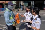 Tim dari Politeknik Transportasi Darat Bali (POLTRADA Bali) membagikan barang kebutuhan pokok kepada petugas parkir dalam aksi bina lingkungan di Terminal Batubulan, Gianyar, Bali, Sabtu (18/4/2020). Kegiatan tersebut untuk meringankan perekonomian sopir angkutan umum, petugas parkir, petugas kebersihan, pedagang dan ojek online dalam kondisi pandemi COVID-19. ANTARA FOTO/Nyoman Hendra Wibowo/nym.