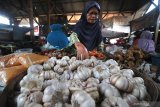 Pedagang menata bawang putih dagangannya di Pasar Kolpajung, Pamekasan, Jawa Timur, Minggu (19/4/2020). Menjelang bulan Ramadhan harga Bawang Putih di pasar itu, turun dari Rp40 ribu menjadi Rp28 ribu per Kg. Antara Jatim/Saiful Bahri/zk