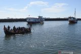 Sejumlah penumpang menaiki perahu penghubung ke darat di Pelabuhan Kalbut, Mangaran, Situbondo, Jawa Timur, Senin (20/4/2020). Penumpang dari Pulau Sapudi, Sumenep mulai datang ke sejumlah pelabuhan di Situbondo untuk membeli kebutuhan sembako menjelang bulan Ramadan dan warga kepulauan tidak menggunakan masker saat beraktivitas di luar rumah di masa pandemi COVID-19. Antara Jatim/Seno/zk.