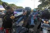 Polisi berpakaian tokoh wayang memeriksa suhu badan warga yang memasuki Surabaya di pintu keluar Jembatan Suramadu, Surabaya, Jawa Timur, Senin (20/4/2020). Kegiatan itu untuk menghambat dan memutus penyebaran Covid-19. Antara Jatim/Didik/Zk