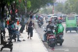 Sejumlah pengemudi ojek online menunggu orderan di trotoar jalan Ahmad Yani, Banjarmasin,Kalimantan Selatan, Senin (20/4/2020). Pemerintah Kota Banjarmasin bersiap terapkan Pembatasan Sosial Berskala Besar (PSBB) pada Jumat (24/4/2020) usai disetujui oleh Menteri Kesehatan Terawan Agus Putranto untuk upaya percepatan penanganan virus COVID-19. Foto Antaranews Kalsel/Bayu Pratama S.  