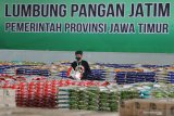 Pekerja beraktivitas di Lumbung Pangan Jawa Timur di JX International, Surabaya, Jawa Timur, Senin (20/4/2020). Lumbung Pangan Jawa Timur yang menjual kebutuhan pokok dengan harga murah tersebut disediakan oleh Pemerintah Provinsi Jawa Timur untuk membantu meringankan beban ekonomi masyarakat di tengah pandemi COVID-19. Antara Jatim/Moch Asim/zk.