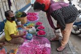 Penjual bunga tabur melayai pembeli di sebuah trotoar di Kota Madiun, Jawa Timur, Senin (20/4/2020). Menurut penjual, menjelang Ramadan terjadi peningkatan omzet dari rata-rata Rp200 ribu hingga Rp250 ribu per hari menjadi Rp400 ribu hingga Rp500 ribu per hari, karena sebagian warga sudah mulai melakukan ziarah kubur. Antara Jatim/Siswowidodo/zk