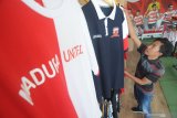 Calon pembeli mengamati jersey Madura United FC (MUFC) di Distro MUFC, Pamekasan, Jawa Timur, Senin (20/4/2020). Pasca diberhentikannya kompetisi Liga 1 2020 karena pendemi COVID-19, menyebabkan omzet dari penjualan atribut MU menurun dari sekitar Rp16 juta menjadi Rp2 juta hingga Rp5 juta per bulan. Antara Jatim/Saiful Bahri/zk