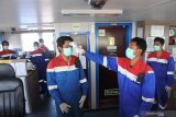 Petugas kesehatan memeriksa suhu tubuh Anak Buah Kapal (ABK) saat isolasi mandiri di kapal LPG tanker Gas Arar milik PT Pertamina di perairan Pelabuhan Kalbut, Mangaran, Situbondo, Jawa Timur, Rabu (22/4/2020). Sejak 16 Maret 2020 kru ABK tersebut melakukan isolasi mandiri di atas kapal, tidak turun ke darat guna mencegah COVID-19. Antara Jatim/Seno/zk.