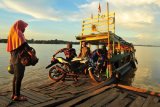 Warga memanfaatkan jasa penyeberangan sepeda motor di Sungai Batanghari, Muarojambi, Jambi, Selasa (21/4/2020). Penyedia jasa penyeberangan yang melayani rute Taman Rajo-Maro Sebo tersebut mematok tarif Rp10 ribu per sepeda motor. ANTARA FOTO/Wahdi Septiawan./hp.