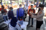 Kapolsek Waru, Kompol Anwar Sudjito memeriksa Kartu Tanda Pengenal penumpang saat tiba di kedatangan Terminal Bungurasih, Sidoarjo, Jawa Timur, Kamis (23/4/2020). Pemerintah Indonesia resmi mengeluarkan kebijakan larangan mudik Lebaran 2020 bagi masyarakat di tengah masa Pandemi guna memutus mata rantai penyebaran virus corona atau COVID-19 yang akan berlaku ekfektif mulai Jumat 24 April 2020. Antara Jatim/Umarul Faruq/zk