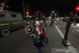 Petugas memberikan himbauan kepada pengguna jalan yang akan masuk kedalam Kota di perbatasan Kota Banjarmasin, Kalimantan Selatan, Jumat (24/4/2020) malam. Saat pemberlakuan jam malam untuk mendukung Pembatasan Sosial Berskala Besar (PSBB) di Kota Banjarmasin, jalan masuk menuju dalam kota di tutup namun boleh masuk dengan akses terbatas melalui pemeriksaan oleh petugas guna mencegah penyebaran COVID-19. Foto Antaranews Kalsel/Bayu Pratama S.